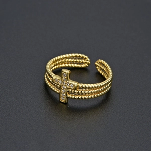 Detailed view of gold multi-layer cross ring with sparkling zircon stones and open band