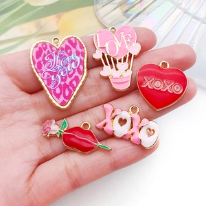 Présentation à la main de breloques en alliage cœur et rose pour bijoux DIY