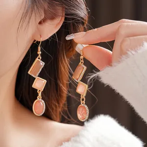 Vintage gold-plated long earrings with orange cat-eye stones and rhinestones