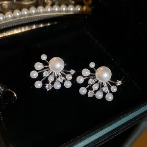 Elegant pearl firework stud earrings with silver pins and cubic zirconia in a velvet box