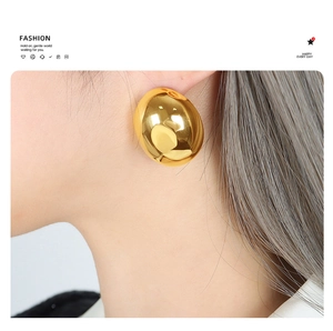 Polished gold-tone geometric oval earrings on model showing minimalist chic style