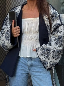 Detail of blue and white paisley quilted jacket with V-neck tie closure for women