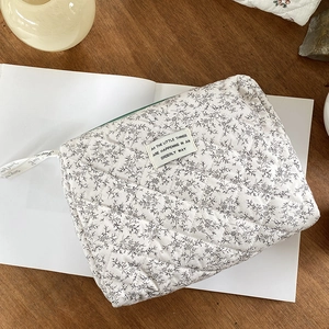 Detail of floral quilted cotton makeup bag with green zipper and motivational text