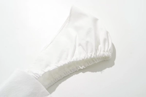 Detailed macro view of the white cotton dress sleeve with elastic cuff stitching