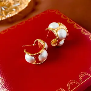 Vintage C-shaped gold-tone earrings with four large white pearls and beaded edges