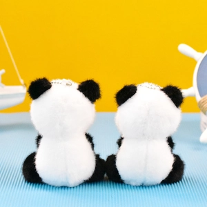 Vista trasera de dos llaveros de peluche de panda sobre un fondo brillante y alegre