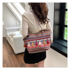 Close-up of colorful geometric woven tote bag with vibrant bohemian tassels detail