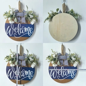 Macro view of 29cm wooden door sign with Welcome script, artificial flowers and burlap bow