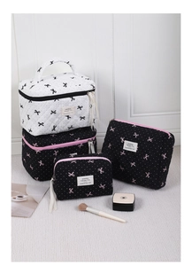 Detail of 4-piece quilted cotton cosmetic bag set with pink and black bow pattern