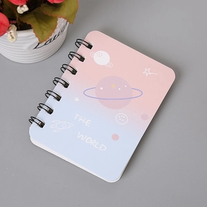 Detail of pink-blue gradient spiral notebook with cute space-themed rocket and stars