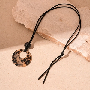 Detail of retro acrylic leopard print ring pendant on a black adjustable cord necklace