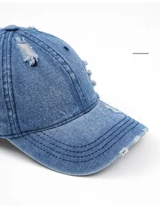 Detail shot of distressed blue denim baseball cap featuring vintage frayed edge textures