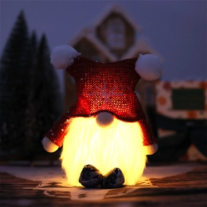 Glow Christmas Gnome with LED beard and red snowflake hat on festive wood background