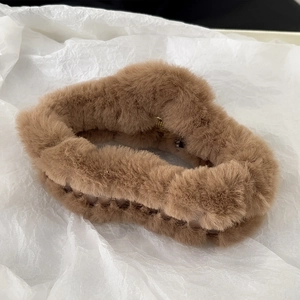 Detailed view of brown plush faux fur hair claw clip with warm winter texture
