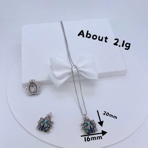 Fashionable copper beetle pendant set with colorful zircon inlay on a white display stand