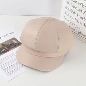 Detailed close-up of beige PU leather newsboy cap showing soft texture and fine stitching