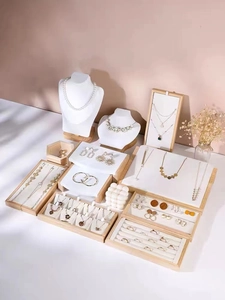 Detailed macro view of solid wood and white leather jewelry display stands set