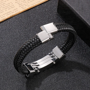 Close-up of black braided leather bracelet with silver wave-patterned stainless steel clasp