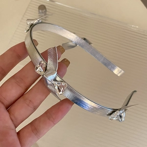 Dettaglio del cerchietto argento con cristalli a forma di cuore e fiocchi metallici