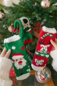 Gros plan de chaussettes de Noël en polaire corail avec motifs Père Noël et renne
