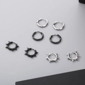 Detail of silver and black stainless steel mobius and spike hoop earrings set