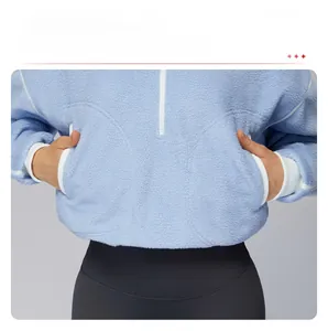 Detail view of double side pockets on light blue fleece sports jacket with elastic hem