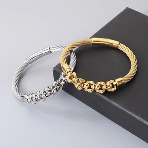 Detail of skull cable wire bracelets in gold and silver finish with metallic texture