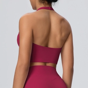 Dettaglio del dorso a incrocio del reggiseno sportivo rosso scuro e dei leggings yoga