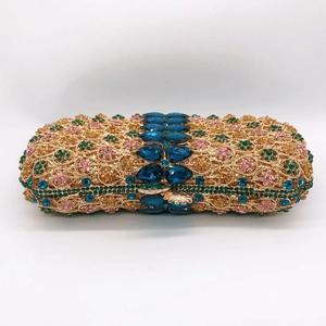 Macro view of crystal-encrusted hollow metal evening clutch with blue gemstones