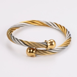 Macro detail of twisted cable wire bracelet with two-tone finish and gold end balls