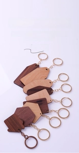 Various wooden hotel keychains in geometric shapes with metal rings and clear grain texture