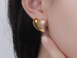 Macro shot of a heart-shaped stud earring with gold and cubic zirconia split design