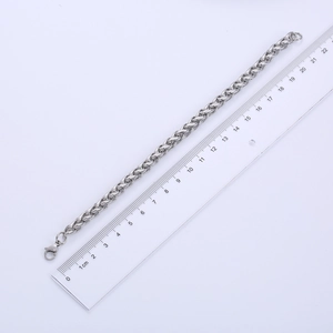 Detailed view of a 7mm silver stainless steel chain bracelet next to a metric ruler