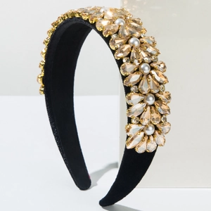 Detail of baroque headband with champagne crystals and white pearls on black velvet