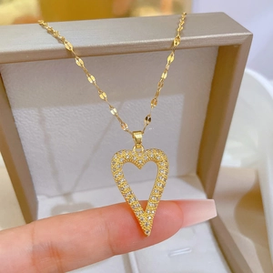 Close-up of golden hollow heart necklace with sparkling diamonds and elegant fine chain