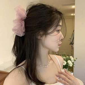 Close-up of a pink mesh bow hair claw clip styled on a ponytail for a summer look