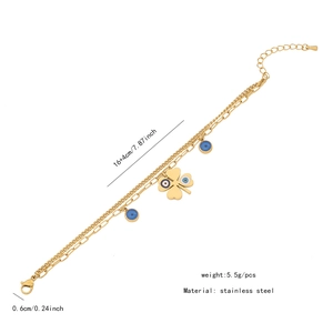 Detailed view of a gold stainless steel double chain bracelet with clover and evil eye