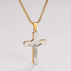 Détail macro d'un pendentif crucifix religieux en acier inoxydable bicolore or et argent