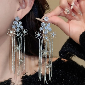 Détail de boucles d'oreilles élégantes en fleurs d'argent avec des strass étincelants