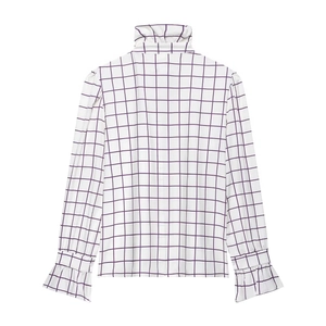 Detail of purple and white plaid shirt featuring high ruffled collar and flared cuffs