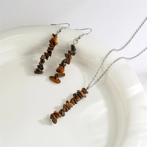 Tiger eye stone necklace and earring set displayed on a white ceramic plate