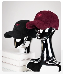 Detail of lamb wool baseball caps with bow embroidery on metallic model heads