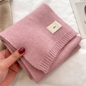 Close-up of pink knitted scarf showing soft texture and emo brand label detail