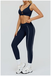 Détail d'un ensemble de yoga bleu marine avec brassière ajourée et legging à rayures latérales