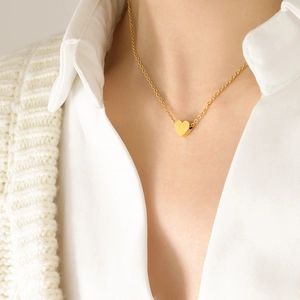 Elegant gold heart pendant necklace on a model with a minimalist stainless steel chain