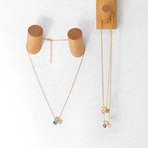 Detailed view of three gold-tone necklaces featuring heart motifs and colorful round zircon stones