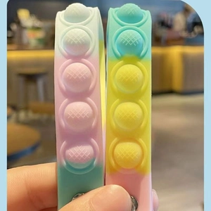 Detail of colorful pop-it silicone bracelets with blue pink and yellow gradient colors