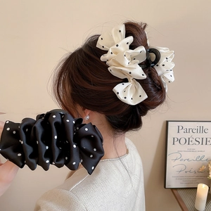Close-up of vintage polka dot fabric hair claw clips on hair with elegant satin texture