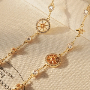 Elegant gold bracelet with sparkling zircon compass star charms and orange gemstone