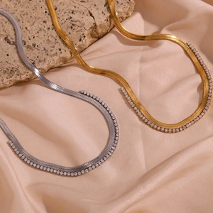 Detail of gold and silver herringbone chains with micro-paved cubic zirconia stones